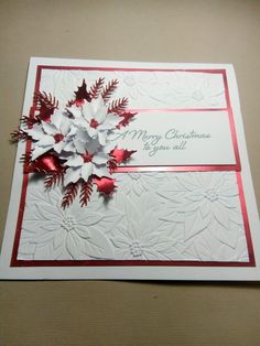 a christmas card with red and white paper flowers