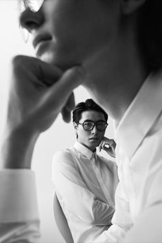 black and white photograph of a woman in glasses looking off to the side with her hand on her chin