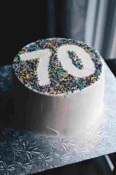 a white cake with sprinkles and the number 90 on it