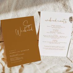 two wedding programs are laying on a bed