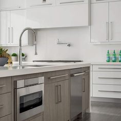 a kitchen with white cabinets and stainless steel appliances