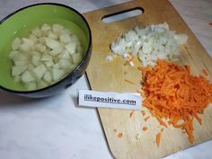 chopped carrots and onions on a cutting board next to a bowl