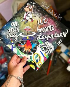 someone is holding up a graduation cap that says, on this day we become legendary