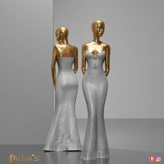 two gold and silver mannequins are standing next to each other in front of a mirror