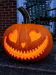 a carved pumpkin with hearts on it