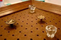 some glass knobs are sitting on a wooden table with holes in the top and bottom