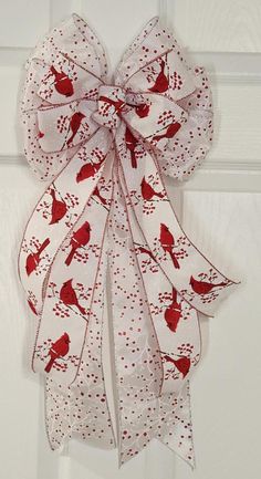 a white door with a red bird on it's bow hanging from the side