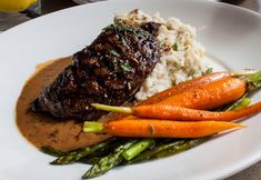 steak, mashed potatoes and asparagus on a plate with gravy