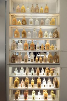 shelves filled with lots of different types of bottles and jars in a glass display case