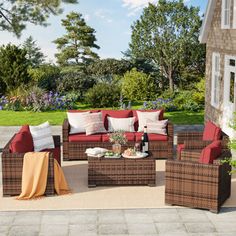 an outdoor patio with wicker furniture and red cushions