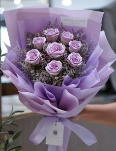 a bunch of purple roses wrapped in paper