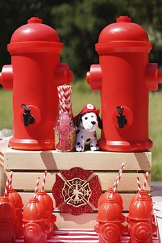 a red fire hydrant sitting on top of a wooden crate filled with candy canes