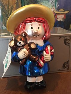 a ceramic figurine holding a teddy bear