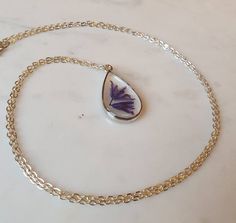 This listing is for a real bluebell stem handpicked and pressed from my garden containing 2 flower heads.  This is set in resin inside a tear drop shaped silver effect bezel pendant on a 24" silver effect chain.This necklace is so beautiful and one of a kind. It would make the perfect gift for someone special.  Please note there are many tiny bubbles in the resin as you can see in the photos.Please visit my shop to see all the other types of pressed flower necklaces for sale. Minimalist Silver Jewelry With Pressed Flowers, Silver Jewelry With Pressed Flowers For Mother's Day, Delicate Teardrop Jewelry For Her, Delicate Teardrop Jewelry As Gift For Her, Teardrop Sterling Silver Keepsake Jewelry, Sterling Silver Teardrop Keepsake Jewelry, Handmade Teardrop Jewelry As Gift For Her, Teardrop Jewelry With Pressed Flowers, Pressed Flowers Pendant Jewelry Gift