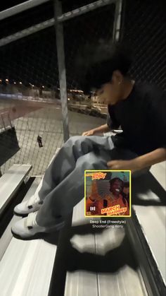 a man sitting on top of a metal bench