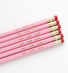 four pink pencils with gold writing on them that say you look good, you look good