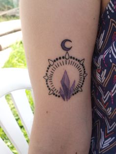 a woman's arm with a tattoo on it that has an arrow and the moon