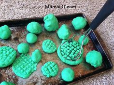 green frosted cookies on a baking sheet with a spatula in the shape of waffles