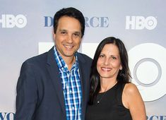 a man and woman standing next to each other in front of a white wall with the hbo logo on it