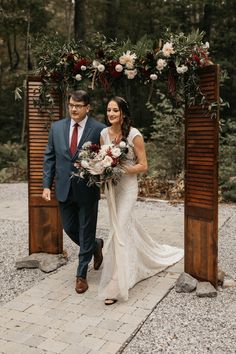 a bride and groom walking down the aisle at their outdoor wedding ceremony in the woods