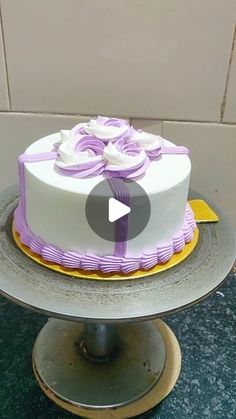 a white and purple cake sitting on top of a table