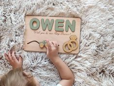 a child is playing with a wooden sign