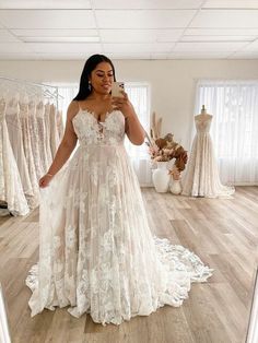 a woman taking a selfie in her wedding dress while looking at her cell phone