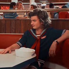 a young man sitting at a table in a restaurant