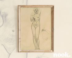 a drawing of a naked woman hangs on the wall