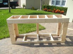 a wooden table sitting on top of a brick sidewalk