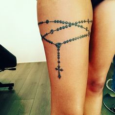 a woman with a rosary tattoo on her leg