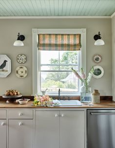 the kitchen is clean and ready to be used for cooking or baking, with dishes hanging on the wall above the sink