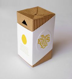 an open box with two eggs inside on a white surface, the packaging is empty