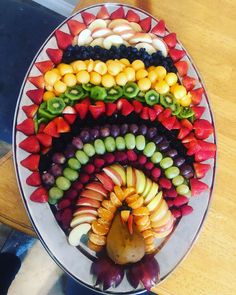 a platter filled with fruits and vegetables on top of a wooden table