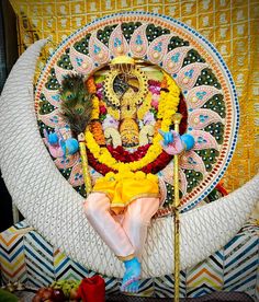 there is a man sitting on the moon with flowers and feathers around his body, surrounded by other decorations