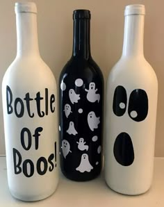 three bottles with black and white designs on them