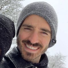 a man and woman are smiling in the snow