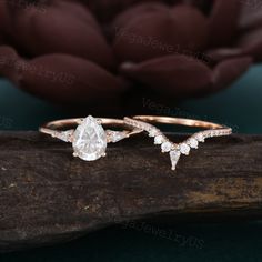 two engagement rings sitting on top of a piece of wood