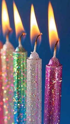 several candles with colored sparkles are lined up