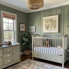 a baby's room with green walls and furniture