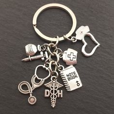 a metal keychain with various medical items attached to it on a black surface