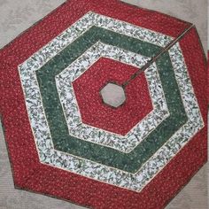 a red and green quilted umbrella laying on the ground