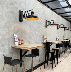 an empty restaurant with tables and chairs in front of a wall that has several lights on it