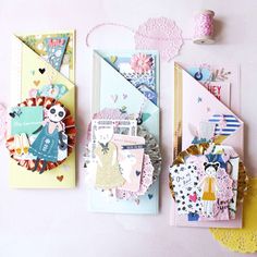 three cards with different types of paper and doily attached to them on a table