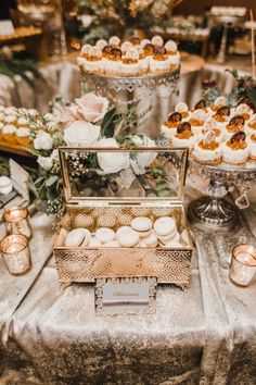 a table topped with lots of cakes and cupcakes on top of a table