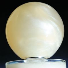 a white ball sitting on top of a glass container