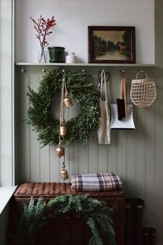 a christmas wreath hanging on the wall next to a basket and other decorations in a room