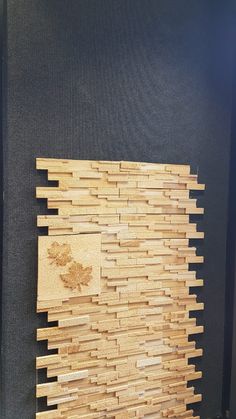 a piece of wood sitting on top of a wooden floor next to a black wall