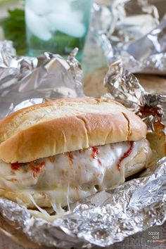 the sandwich is wrapped in tin foil and ready to be eaten on the table,