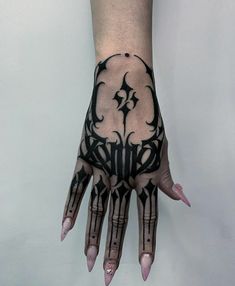 a person's hand with black and white tattoos on it, showing the design